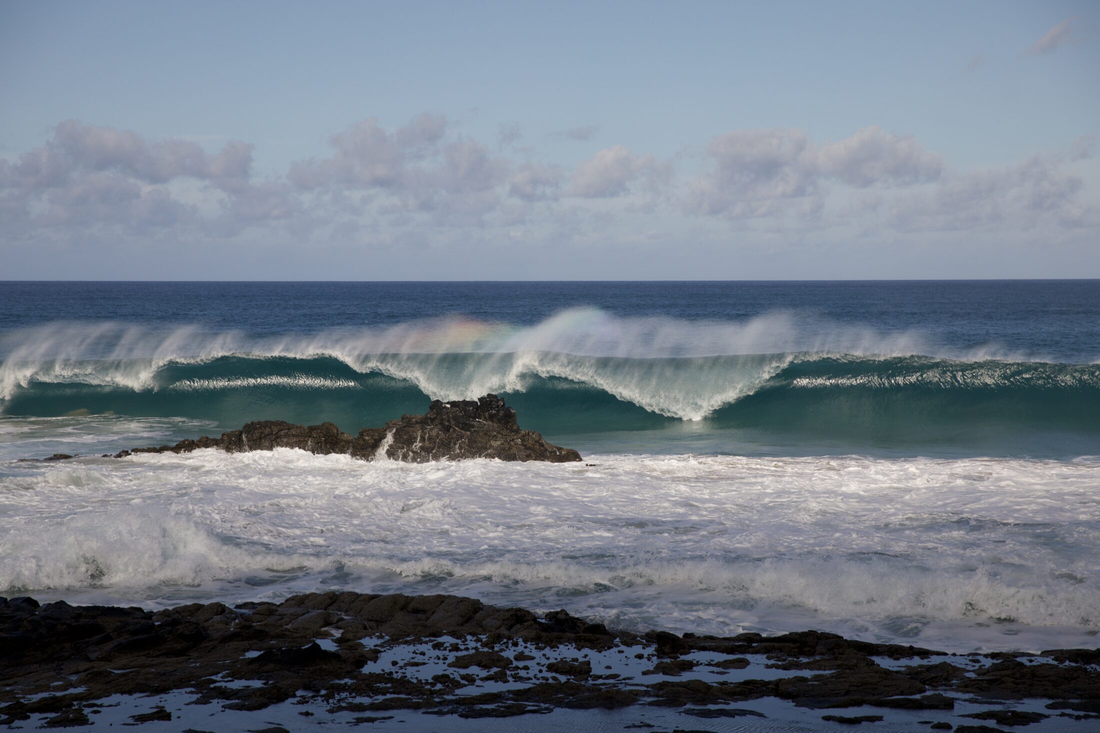 Große Wellen brechen sich an den Felssen vor der Küste