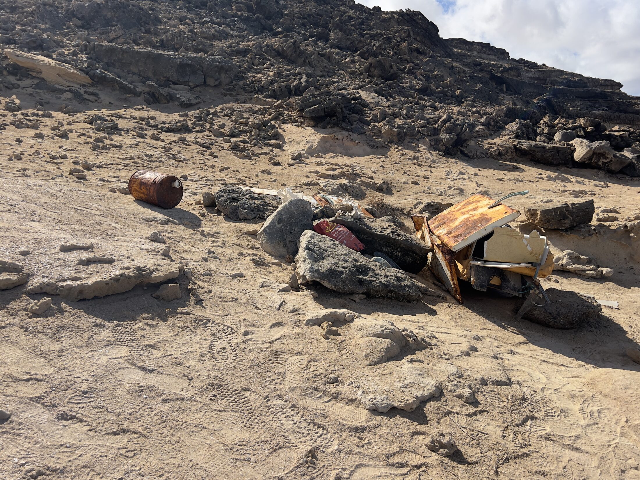 Angeschwemmter Müll liegt zusammengesammelt im Sand