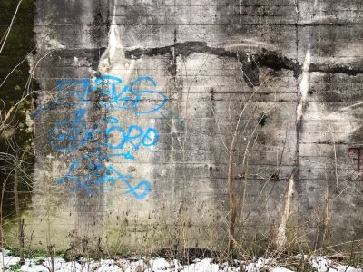 Blaue Graffiti auf einer Betonwand