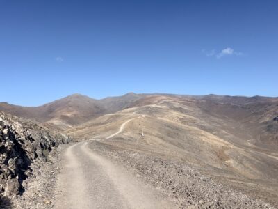 Ein Feldweg über die leichten Hügel der kargen Landschaft. Keine Vegetation ist zu sehen.