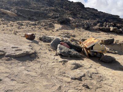 Angeschwemmter Müll liegt zusammengesammelt im Sand